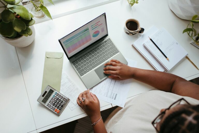 Person working with a laptop and documents at a desk