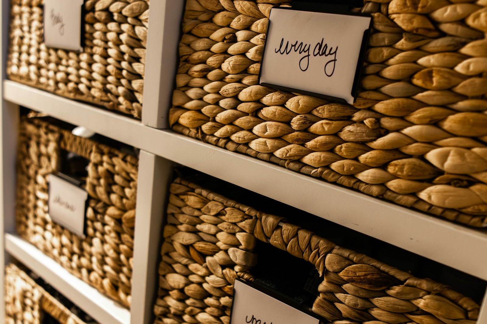 Labeled woven storage baskets arranged on shelves